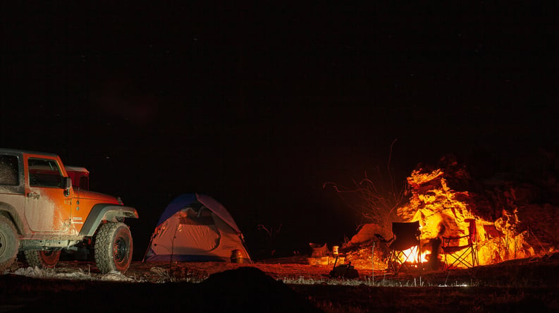 tent set up next to campfire