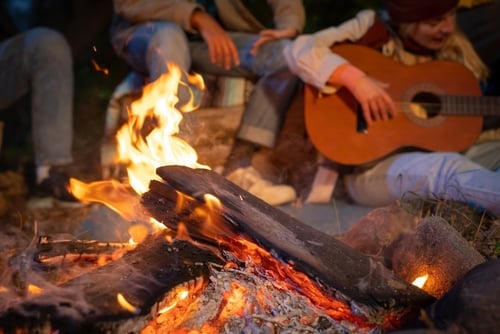 family hanging around campfire